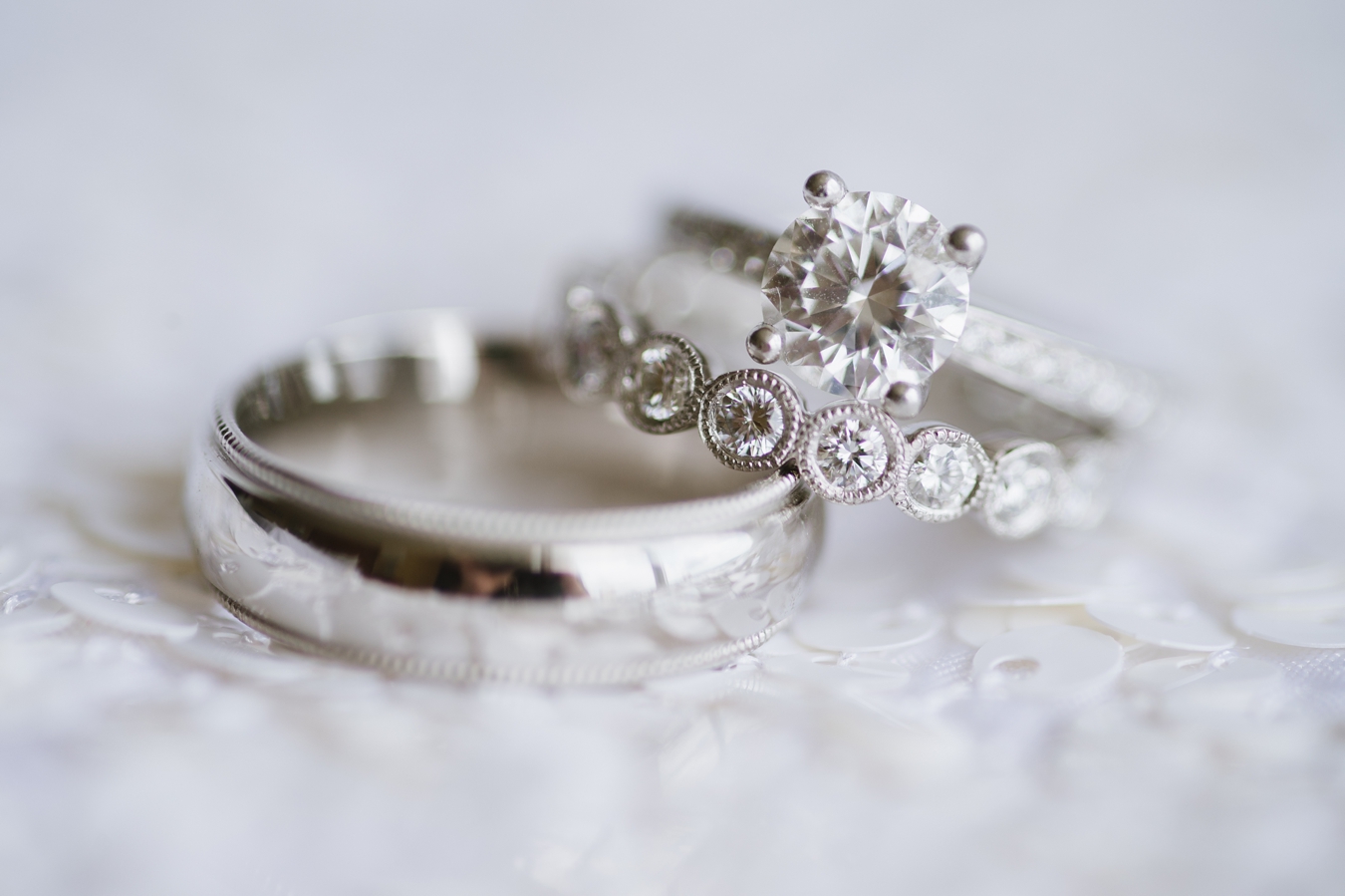 Round Brilliant Engagement Ring on white sequin La Tavola Linen | Natalie Franke Photography